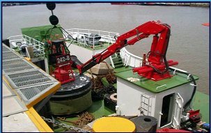 Red knuckle boom crane on a ship deck